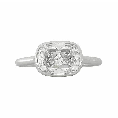 East-West Bezel Solitaire Ring with 9x7mm cushion-cut lab-created diamond simulant set in sterling silver with rhodium plating.