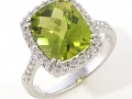 12436 - An 18 karat white gold ring with a cushion brilliant cut peridot weighing 4.18 carats and round brilliant cut diamonds totaling 0.44 carats.