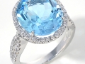 20529 - A 14 karat white gold ring with an oval brilliant cut blue topaz and round brilliant cut diamonds totaling 0.36 carats.